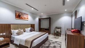 A modern hotel room with a large bed, a TV, a desk, and a mirror. - XYZ Hotel Al Falah (Riyadh)