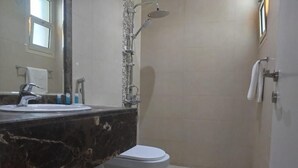 A bathroom with a marble sink, a toilet, and a shower. - XYZ Hotel Al Falah (Riyadh)