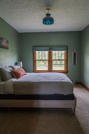 A bedroom with a bed, a window, and a ceiling light fixture. - Palisade Peach Orchard Farmhouse w/Pool & Spa 18+ (Palisade)