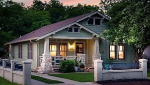 A single-story house with a porch, stone pillars, and a small garden. - Pet-friendly, Hot tub, Close to Main St! (Fredericksburg)