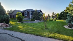 A residential house with a well-maintained lawn, a driveway, and mature trees. - Luxury, Private,Relaxation with beautiful quiet area in the heart of the hills (Rapid City)