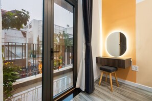 A modern bathroom with a large mirror, a wooden vanity, and a view of the street outside. - Justay Pink Church (Ho Chi Minh City)