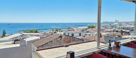 A restaurant with a view of the sea and cityscape.