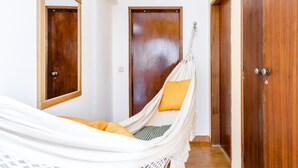 A room with a hammock bed, wooden doors, and a mirror. - Altura Inn Beach - Sol, na Praia, Varanda, Free Wifi e Ar Condicionado (Altura)