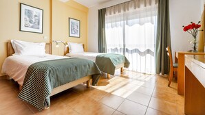 A hotel room with two beds, a desk, and a chair. There are two framed pictures on the wall. - Altura Inn Beach - Sol, na Praia, Varanda, Free Wifi e Ar Condicionado (Altura)