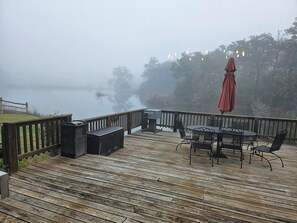 A wooden deck with outdoor furniture, including a table and chairs, and a red umbrella. - 20 minutes from Kyle Field!! (Caldwell)
