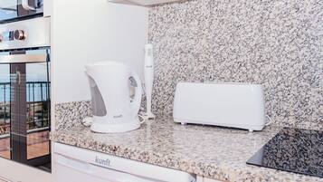 Eine Küche mit Granit Arbeitsplatte, einer Kaffeemaschine, einem Toaster und einem Geschirrspüler.