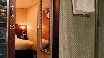 Ein Hotelzimmer mit Bett, Spiegel, Dusche und Handtuchhalter.