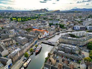 A cityscape with a river, historic buildings, and a mix of residential and commercial structures.