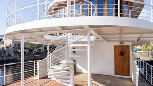 A circular deck with a spiral staircase, a wooden door, and a railing. - Ocean Mist Leith (Edinburgh)