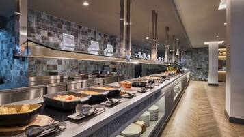 Una mesa de buffet con diferentes alimentos y cubiertos.