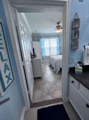 Enter a cozy bedroom with a bed and window, featuring a door with a sign and a ceiling fan.