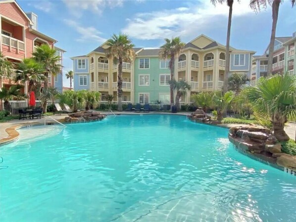 Relax by the pool surrounded by natural rock formations and lush tropical vegetation.