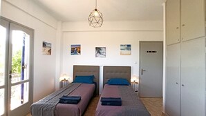 Habitació doble amb dos llits, un armari i una porta.