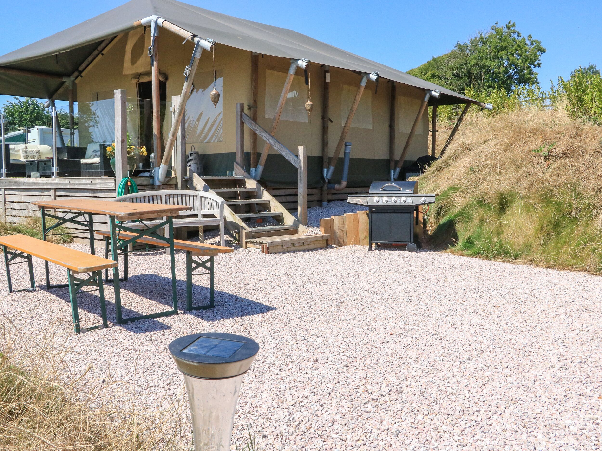 Un espace extérieur abrité, doté de bancs et d’un barbecue.