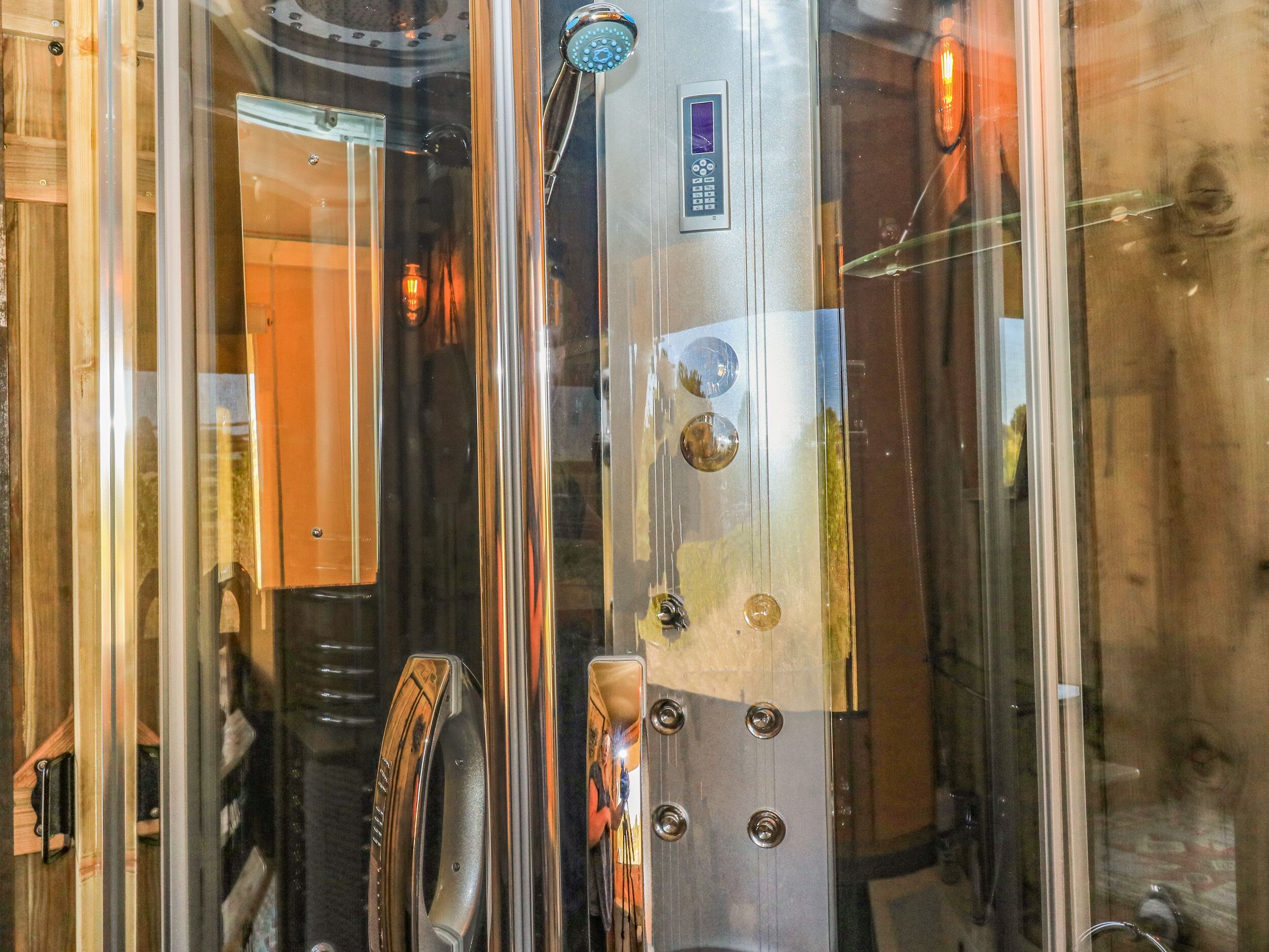 A modern elevator with a metallic finish, a control panel, and a handrail.