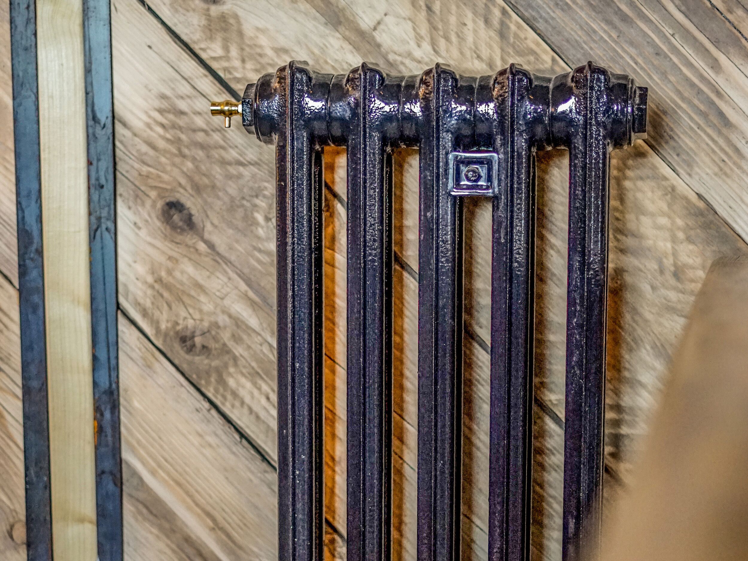 A close-up of a radiator with a visible square-shaped component on its side.