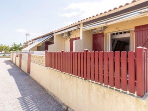 Ein Gebäude mit rotem Zaun, einem überdachten Außenbereich und der Zahl 42 an der Wand.