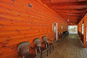 Eine Holzhütte mit Veranda, Holzwänden und einem Willkommensschild.
