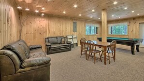A room with a pool table, a leather sofa, and a dining table with chairs. - Maple Ridge Lodge - 5-Bedroom Lodge -Hocking Hills (South Bloomingville)