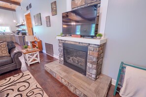A living room with a fireplace, a television, and a sofa. - Chapel Valley Lodge - Unique, in the Hocking Hills (Logan)