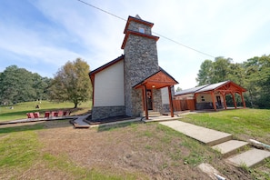 A stone church with a wooden porch and a small adjacent building.