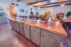 A modern kitchen with a wooden countertop, built-in cabinets, and a dining area with a wooden table and chairs.