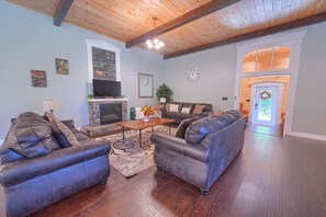 A living room with a fireplace, two sofas, a coffee table, and a TV.