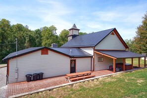A two-story building with a covered porch and a chimney.