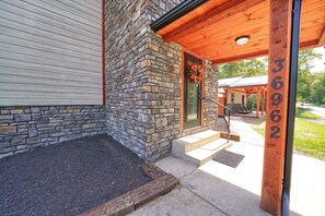 A stone exterior wall, a wooden door with a wreath, and a number sign. - Chapel Valley Lodge - Unique, in the Hocking Hills (Logan)
