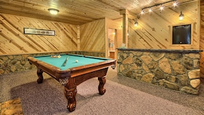 A pool table in a room with wooden walls and a stone accent wall. - Double Pine Lodge - 5 Bedroom -Hocking Hills (Logan)