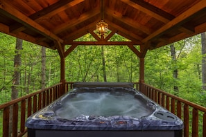 A hot tub in a wooden gazebo surrounded by a forest. - Hunter's Retreat - Cozy Cabin, near Old Man's Cave (Logan)