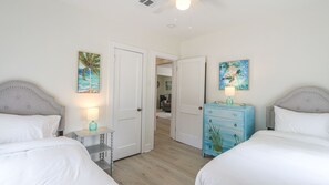 Un dormitorio con dos camas, un aparador y obras de arte en las paredes.