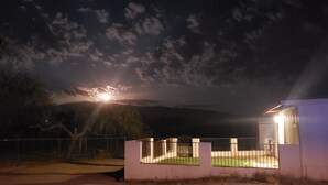 A nighttime scene with a house and a fence. - Ranch Guest House (Tucson)