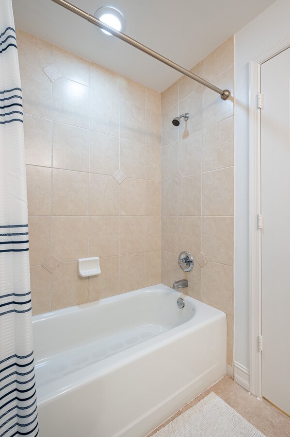 Un baño con bañera, ducha y un perchero para toallas.