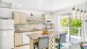 A modern kitchen with a central island, built-in appliances, and a view to the outdoors.