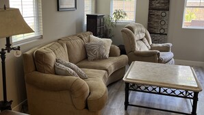 A living room with a beige sofa, a wooden coffee table, and a lamp.