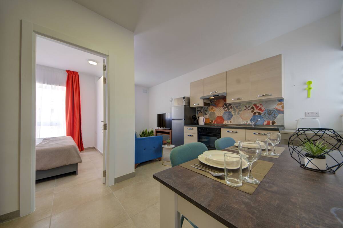 Eine moderne Küche mit Essbereich, einem Bett und einem Badezimmer.
