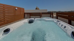 Un jacuzzi sur le toit offrant une vue dégagée sur un bâtiment en forme de dôme situé à l’arrière-plan.
