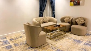 Uma sala de estar com sofá, mesa de centro e tapete estampado.