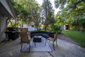 Relax and socialize in this serene outdoor space with a comfortable sofa, chairs, and a convenient table.