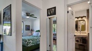 A bedroom with a bed, a ceiling fan, and a window.