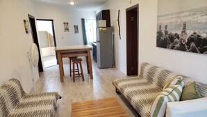 Una sala de estar moderna con un sofá, una mesa de centro y un comedor con una mesa y sillas.