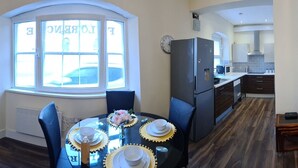A modern living room with a dining area, a kitchen, and a large window. - Florence House , Denbigh (Denbigh)