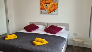 A hotel room with a bed, two pillows, a painting, and a small round table. - Florence House , Denbigh (Denbigh)