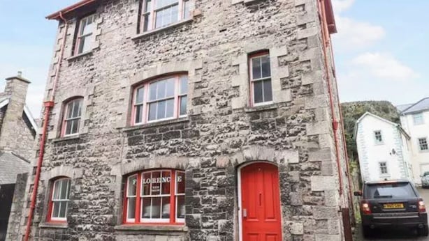 A stone building with a red door and windows, likely a hotel or similar accommodation. - Florence House , Denbigh (Denbigh)