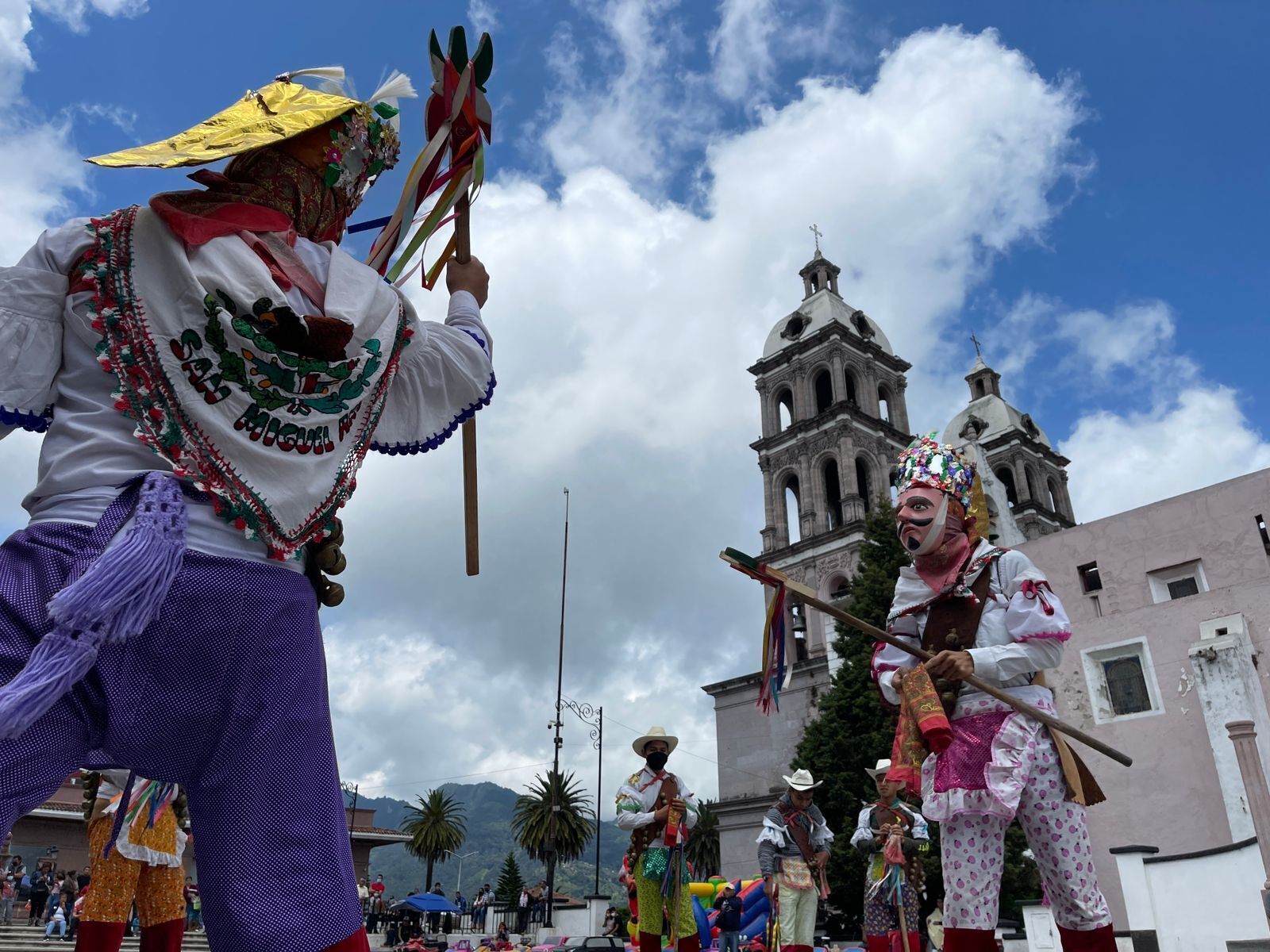 Un grupo de personas vestidas con atuendos tradicionales se presenta frente a un edificio histórico.
