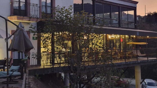 A two-story building with a balcony and outdoor seating area. - Hotel Danini (Teziutlan)