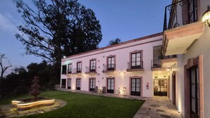 A two-story building with a well-maintained lawn and a fountain. - Hotel Danini (Teziutlan)