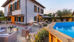 A two-story house with a swimming pool, outdoor seating, and a garden. - Villa Cesare Convenient and Smart (Lucca)